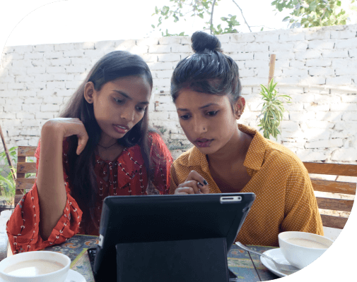 Two young girls watching something intently on a tablet.