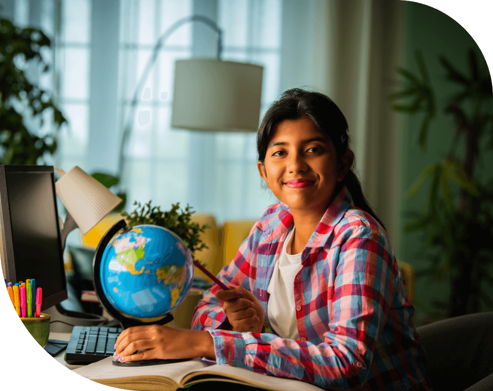 Young girl smiling while sitting at desk.