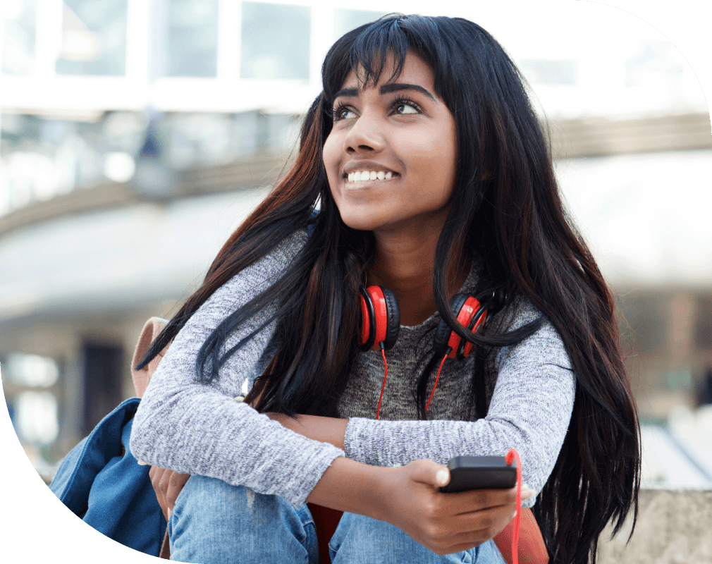 Young teenage girl sitting outside school.