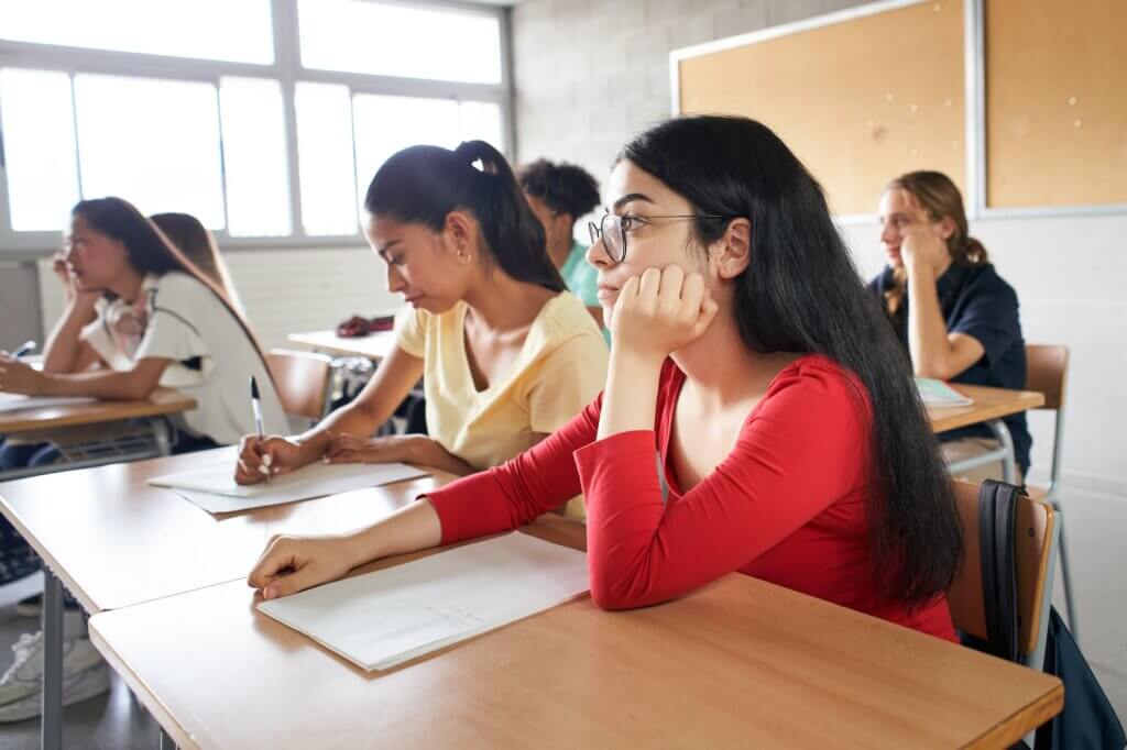 Group of students sitting in class attending to the teacher.